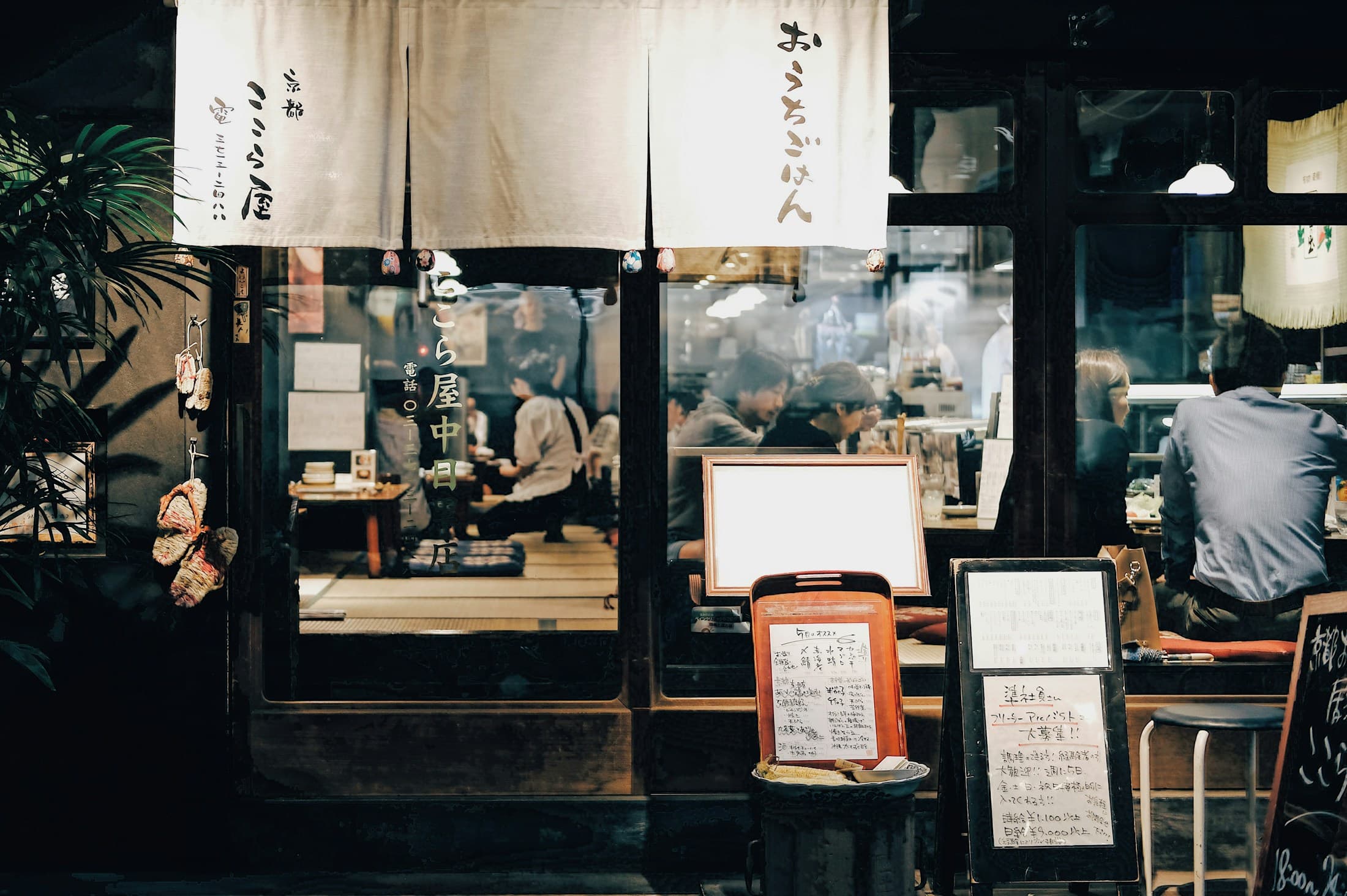 東京の飲食店で働く人と食事を楽しむ人々